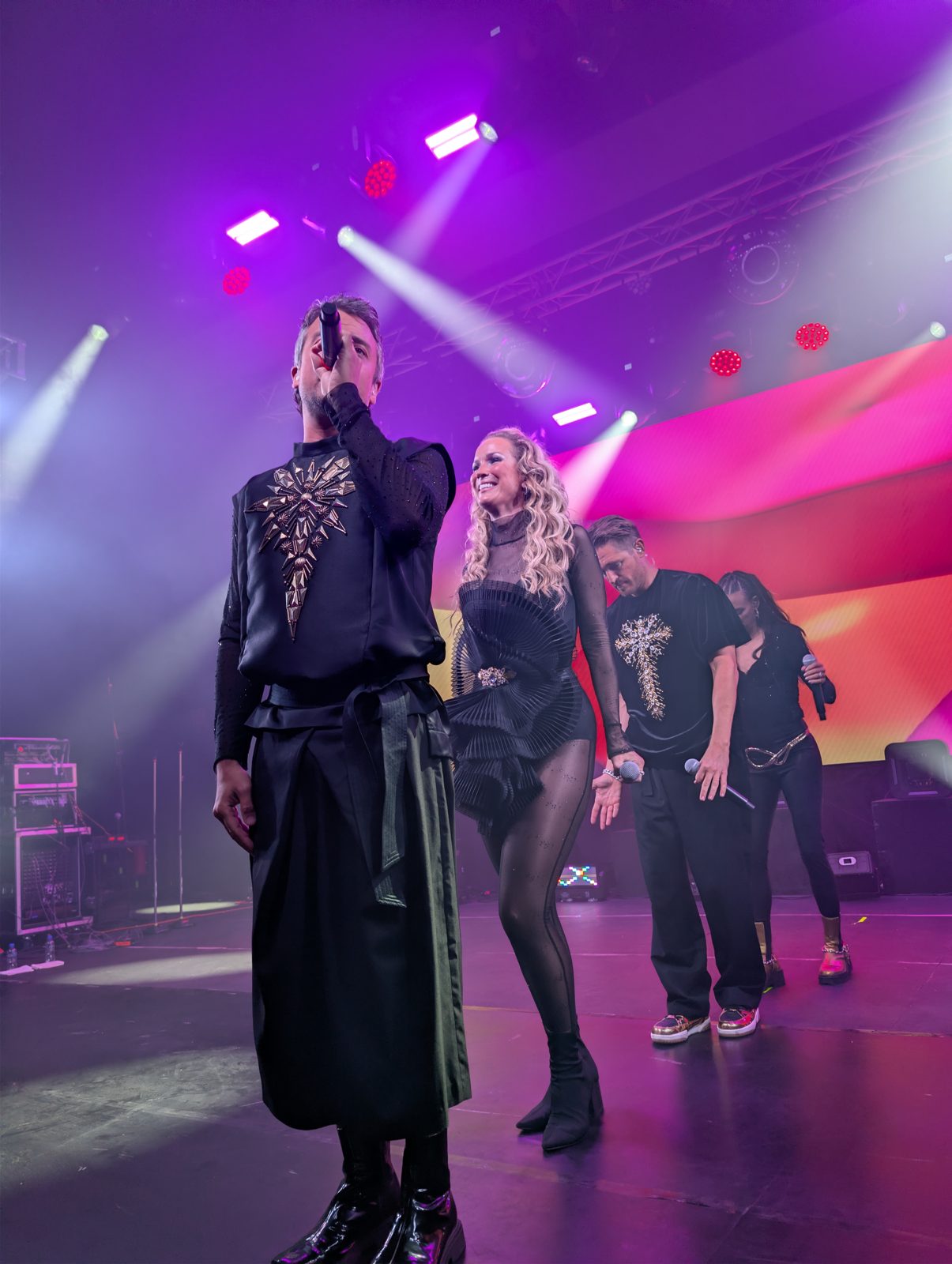 All four A*Teens members performing together under purple stage lights in Mexico City, 2025