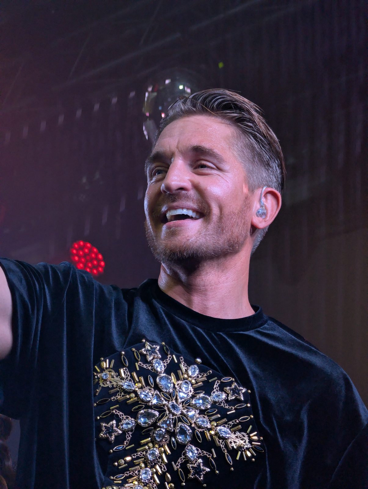 A*Teens member smiling and waving to the crowd on stage in Mexico City, 2025