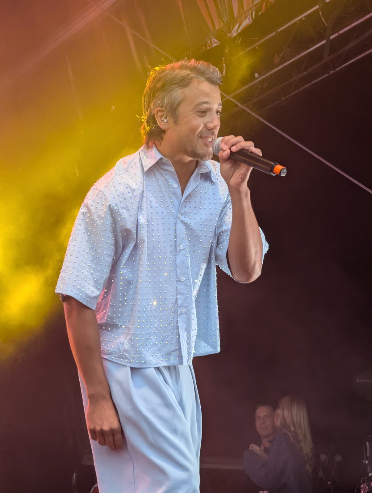 A*Teens member singing under warm stage lighting in Oslo, 2025