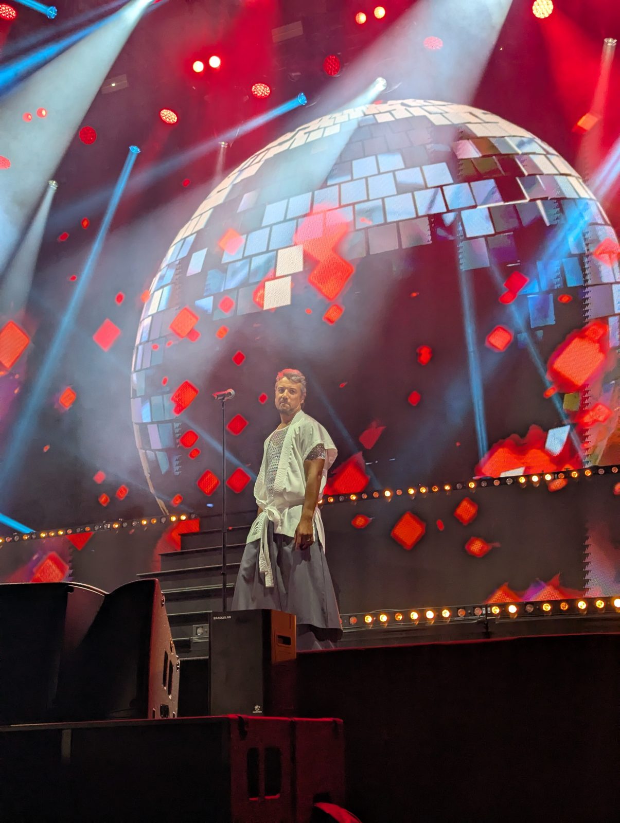 A*Teens member on stage in front of a giant disco ball screen in Stockholm, 2025