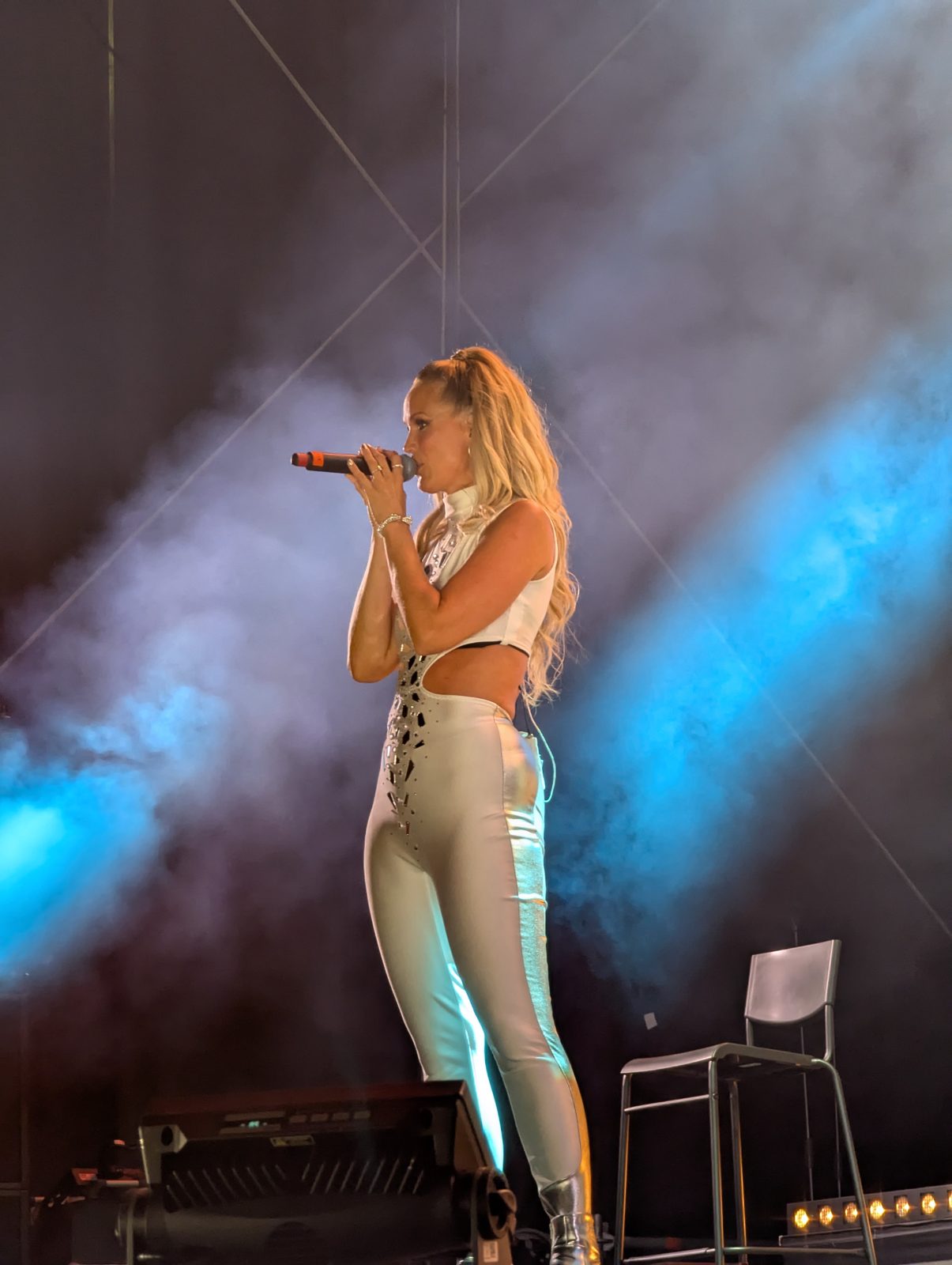 A*Teens member singing in profile under blue stage lighting in Stockholm, 2025
