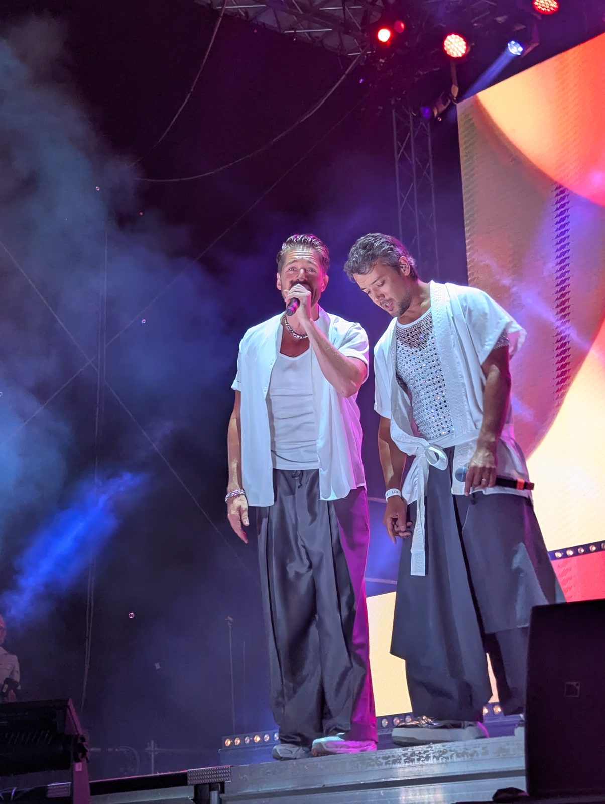Two A*Teens members singing together on stage in Stockholm, 2025