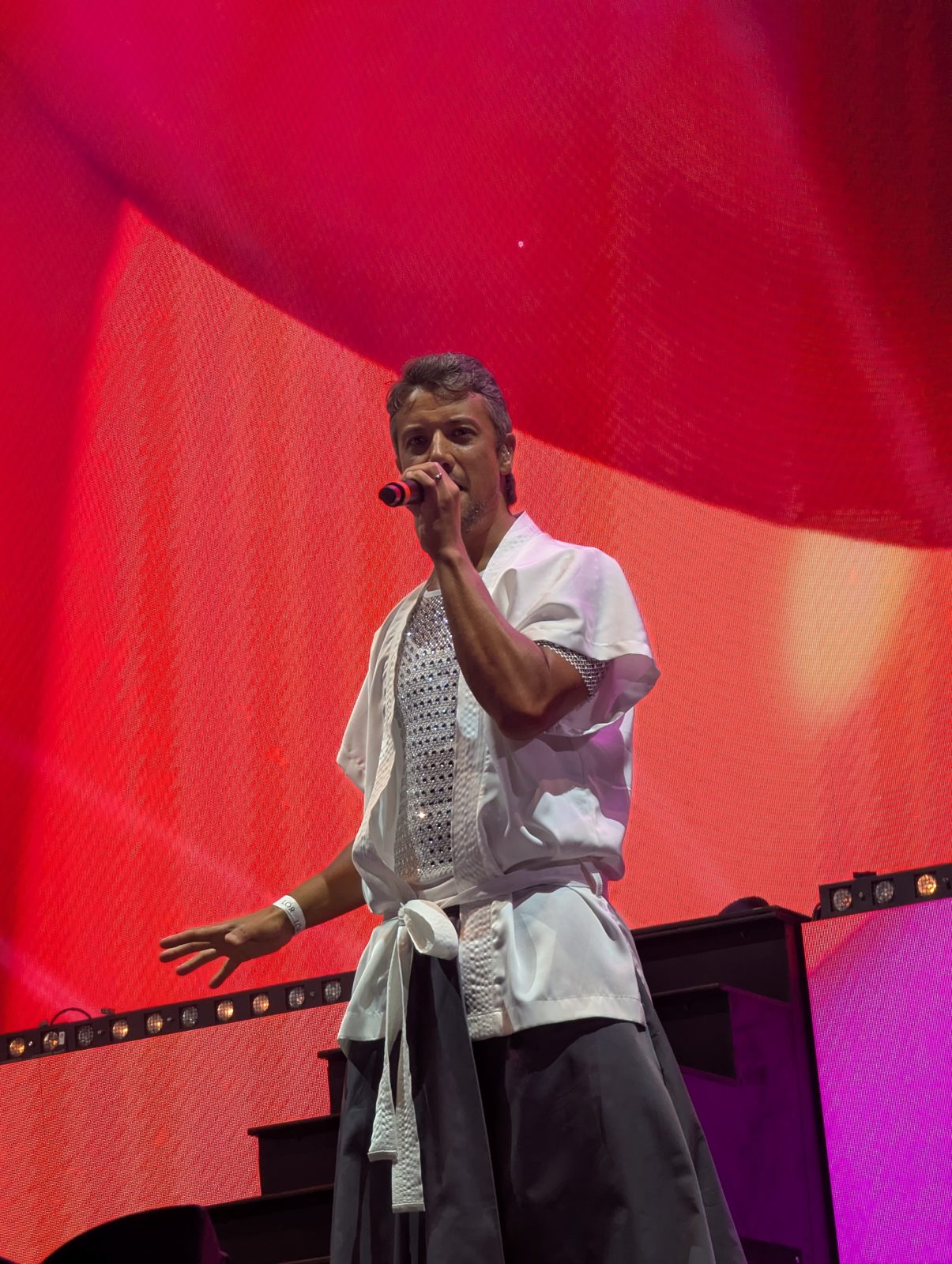 A*Teens member singing on stage under red lighting in Stockholm, 2025
